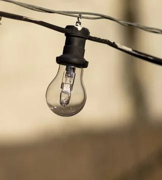 Outdoor party string lights hanging in backyard on green bokeh background w.. Stock Photos