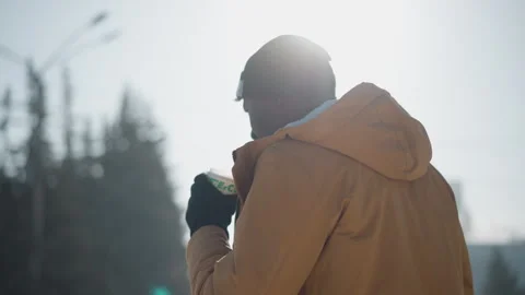 Outdoor photographer drinking beverage while holding camera in winter daylight Vídeo Stock 318627142
