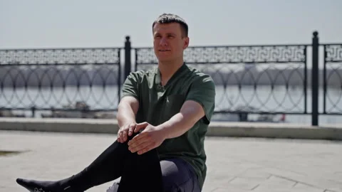 Outdoor physical therapy session with a man providing leg stretching exercises Stock Footage 274206423