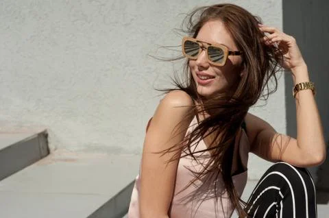 Outdoor portrait of a young beautiful fashionable happy lady, wearing sunglasses Stock Photos