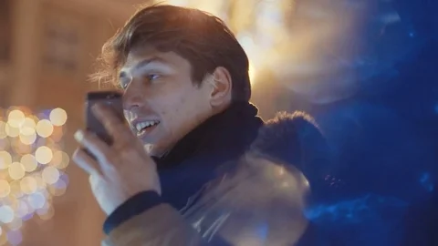 Outdoor portrait of young man using his mobile phone at night. Stock Footage 71222942