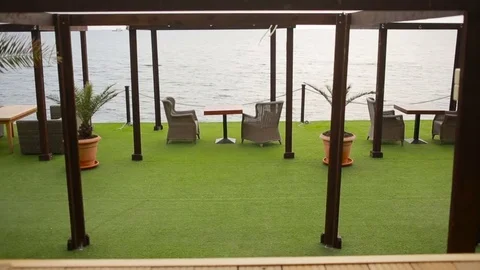 Outdoor restaurant with an empty table and chairs by the sea, Not a season Stock Footage 73811368