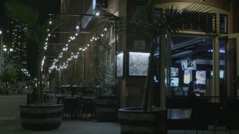 Outdoor Restaurant Patio Illuminated by String Lights at Night Stock Footage 343944247
