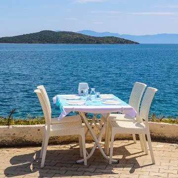 Outdoor restaurant table offering dining with a beautiful sea view in Bitez.. 库存照片