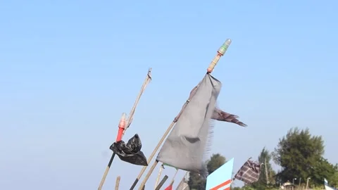 Outdoor scene featuring old weathered flags or poles against a clear blue sky Stock Footage 262638525