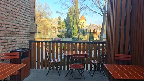 Outdoor seating area with tables, the camera rises higher and focuses on the Stock Footage 301094552