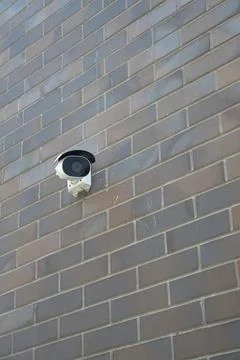 Outdoor security camera mounted on a brick wall Stock Photos