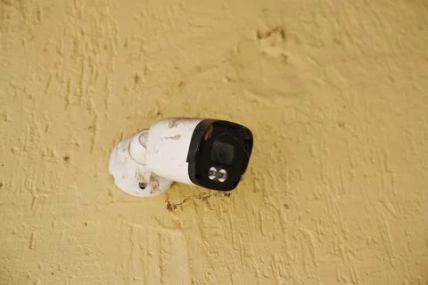 Outdoor security camera mounted on textured wall Stock Photos
