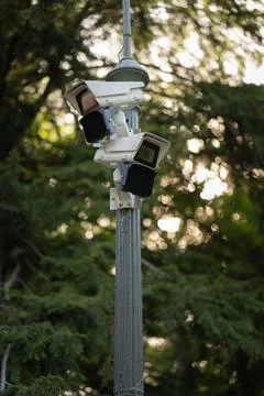 Outdoor security cameras on post in park for public safety monitoring Stock Photos