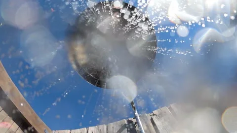 Outdoor shower spraying refreshing water drops against a clear blue sky and Stock Footage 342762837