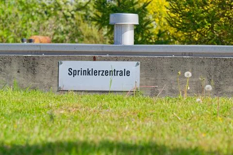 Outdoor sprinkler system control unit with green grass and plants in backgrou Stock Photos
