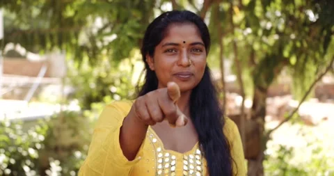 Outdoor static portrait of a person making hand sign gestures looking at camera Stock Footage 145449043