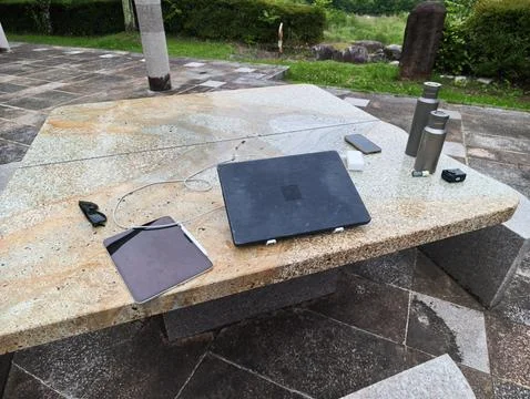 Outdoor stone table holds tech gear Stock Photos