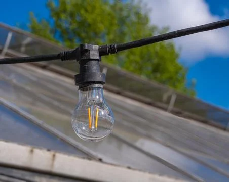 Outdoor string light bulb by greenhouse roof Stock Photos