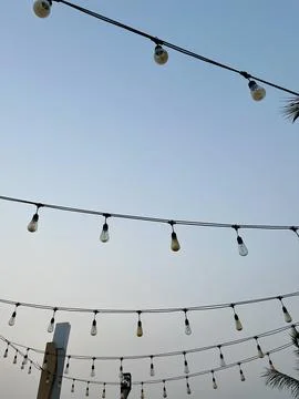 Outdoor String Lights Hanging Against Clear Evening Sky Background at Café Venue Stock Photos