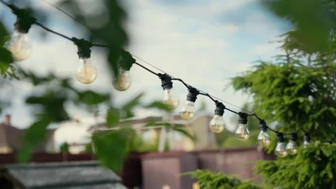Outdoor string lights hanging in a garden backyard Stock Footage 341294690