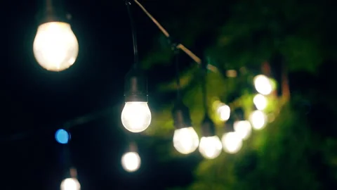 Outdoor string lights hanging on a line on outside house in backyard. Garde.. Stock Footage 253446042