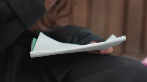 Outdoor studying scene. Student engaged in creative writing outdoors. Closeup of Stock Footage 331360307