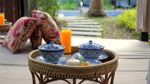 Outdoor summer breakfast setup on wicker table with blue and white porcelain dis Vídeos de archivo 264995684