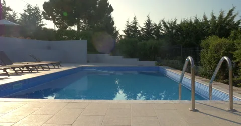 Outdoor swimming pool and empty deck-chairs Stock Footage 61809160