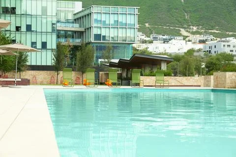 Outdoor swimming pool, hotel and beautiful mountain on background Stock Photos
