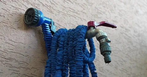 Outdoor tap for watering a garden plot. Water is dripping from the the tap Stock Footage 316840052