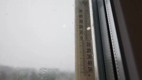 Outdoor Thermometer Displaying Cold Temperatures on a Rainy Window During Winter Stock Footage 335231865