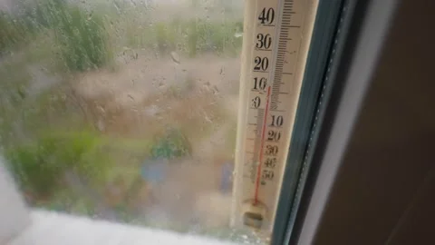 Outdoor Thermometer Measuring Temperature on Rainy Glass Window Pane Stock Footage 335231903