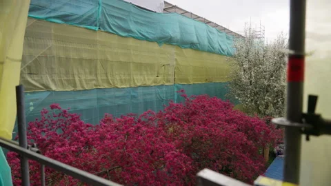 Outdoor View Of A Building Under Construction With Colorful Flowering Trees In Stock Footage 333412383