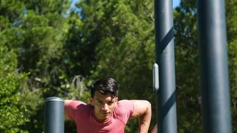 Outdoor workout: man doing tricep dips on park parallel bars Stock Footage 280869016