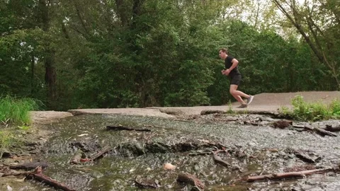 Outdoor workout: man runs through the forest, energizing himself with fresh air Stock Footage 303552178
