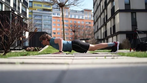 Outdoor workout pushups on sunny day athletic man training in urban courtyard fi Stock Footage 305999894
