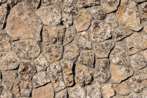 The outer facade of the building is made of natural stone of various shapes Stock Photos