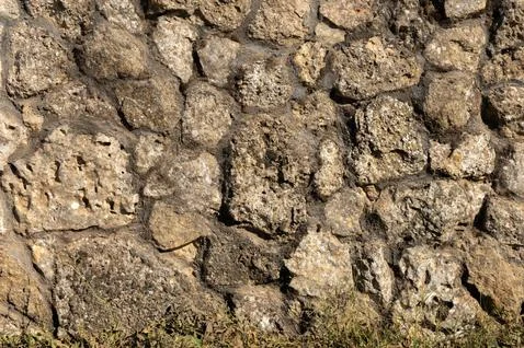 The outer facade of the building is made of natural stone of various shapes Stock Photos