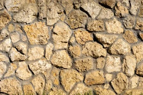 The outer facade of the building is made of natural stone of various shapes Stock Photos