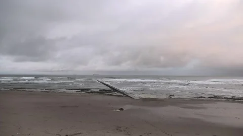 Outfall pipe beach cloudy ship on horizon Stock Footage 260504419
