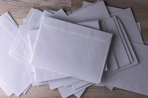 Outgoing correspondence: few empty white envelopes on a wooden desk in the of Stock Photos