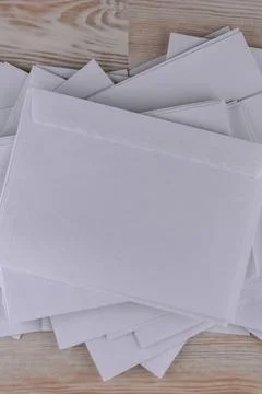 Outgoing correspondence: few empty white envelopes on a wooden desk in the of Stock Photos