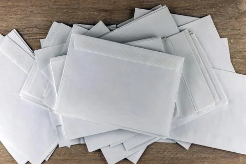 Outgoing correspondence: few empty white envelopes on a wooden desk in the of Stock Photos