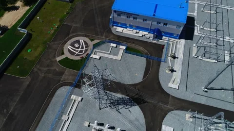 Outgoing power lines building and logo flowerbed at station Stock Footage 154960023