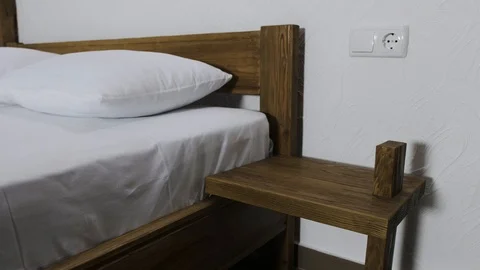 An outlet is next to the double bed in a hotel room with with a mirror on the Stock Footage 89914928