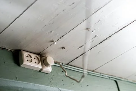 Outlets with a socket mounted at the ceiling in old house with powercord hanging Stock Photos