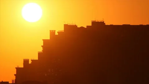 Outlines of sunset sun appear on building wall 스톡 동영상 146038250