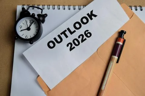 Outlook 2026 text on document above brown envelope. Stock Photos
