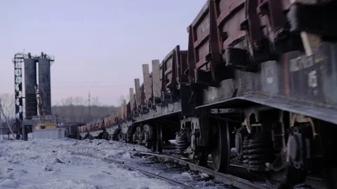 Outlook shot of freight train with empty gondola cars moving along a single Stock Footage 75282803