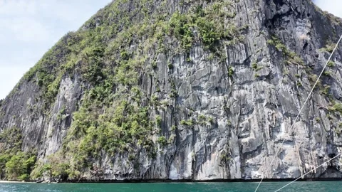 Outrigger Boat beside Dramatic Limestone Cliffs in El Nido Vidéo 347597057