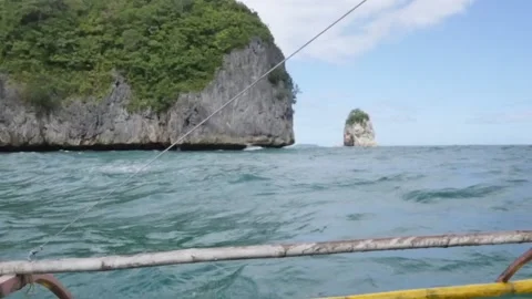 Outrigger Canoe Turquoise Waves Parallel with Islands and Rock Cliffs Video stock 219842170