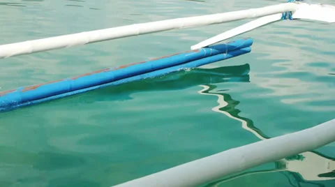 An outrigger reflected on rippling water. Stock Footage 32187248