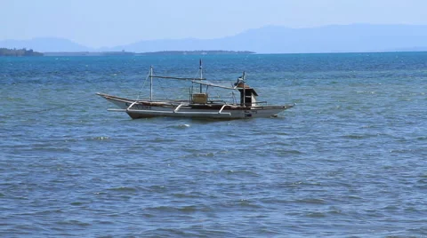 Outrigger sits off a beach in the Philippines Stock Footage 49671651