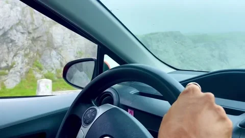 Outside the car window there are rocks and waterfall with approaching fog Stock Footage 251583953